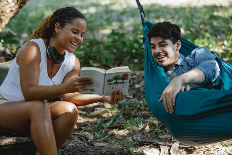 positive multiethnic couple laughing at funny moment in book